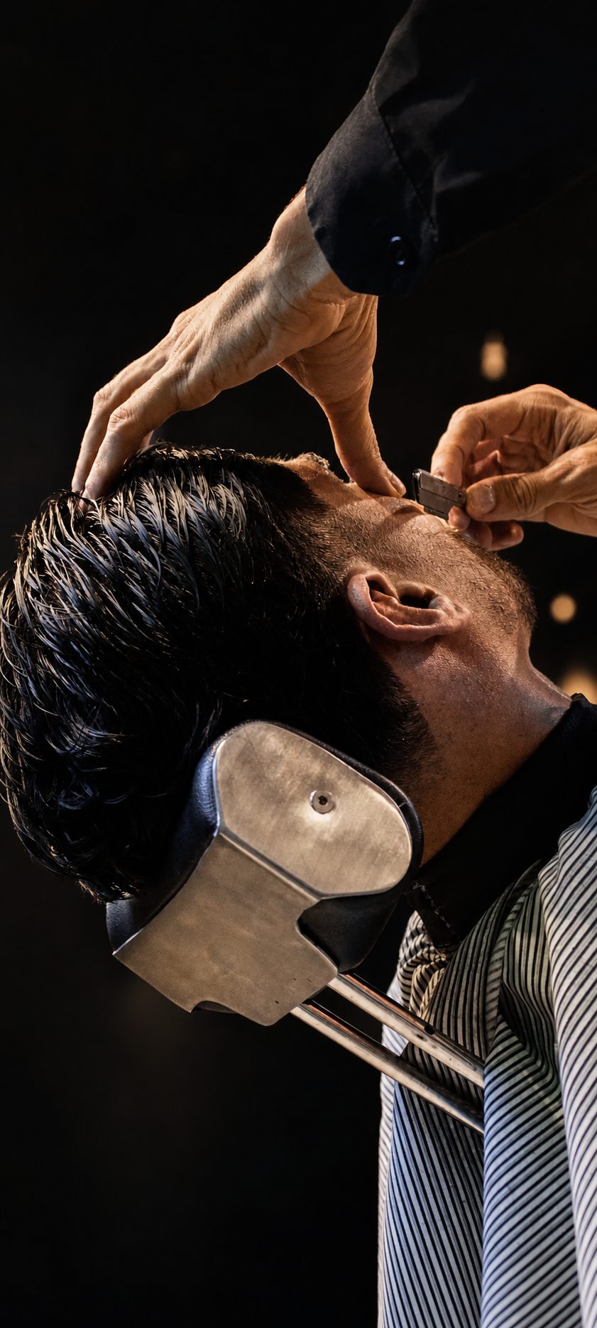 Barbero perfilando con navaja la barba de un cliente en Mostacho Barbería, Ibagué